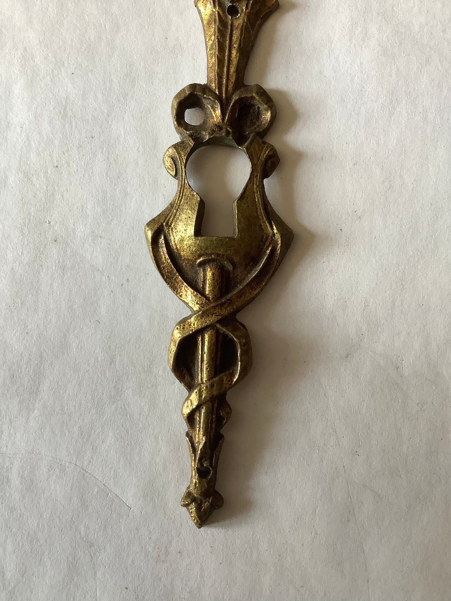 One Antique Brass Ormolu Keyhole Cover Escutcheon made in France in the 1920s elegant torch insignia