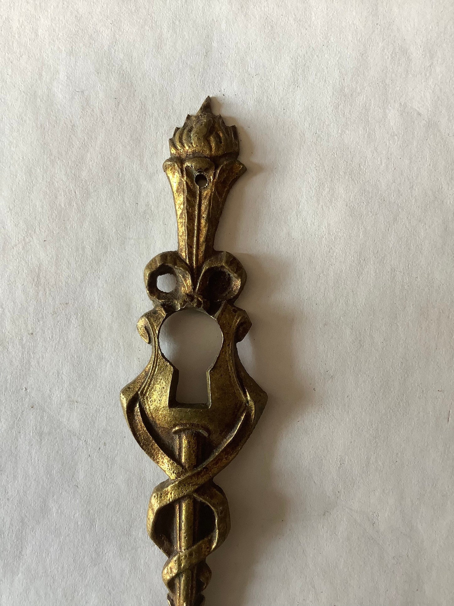 One Antique Brass Ormolu Keyhole Cover Escutcheon made in France in the 1920s elegant torch insignia