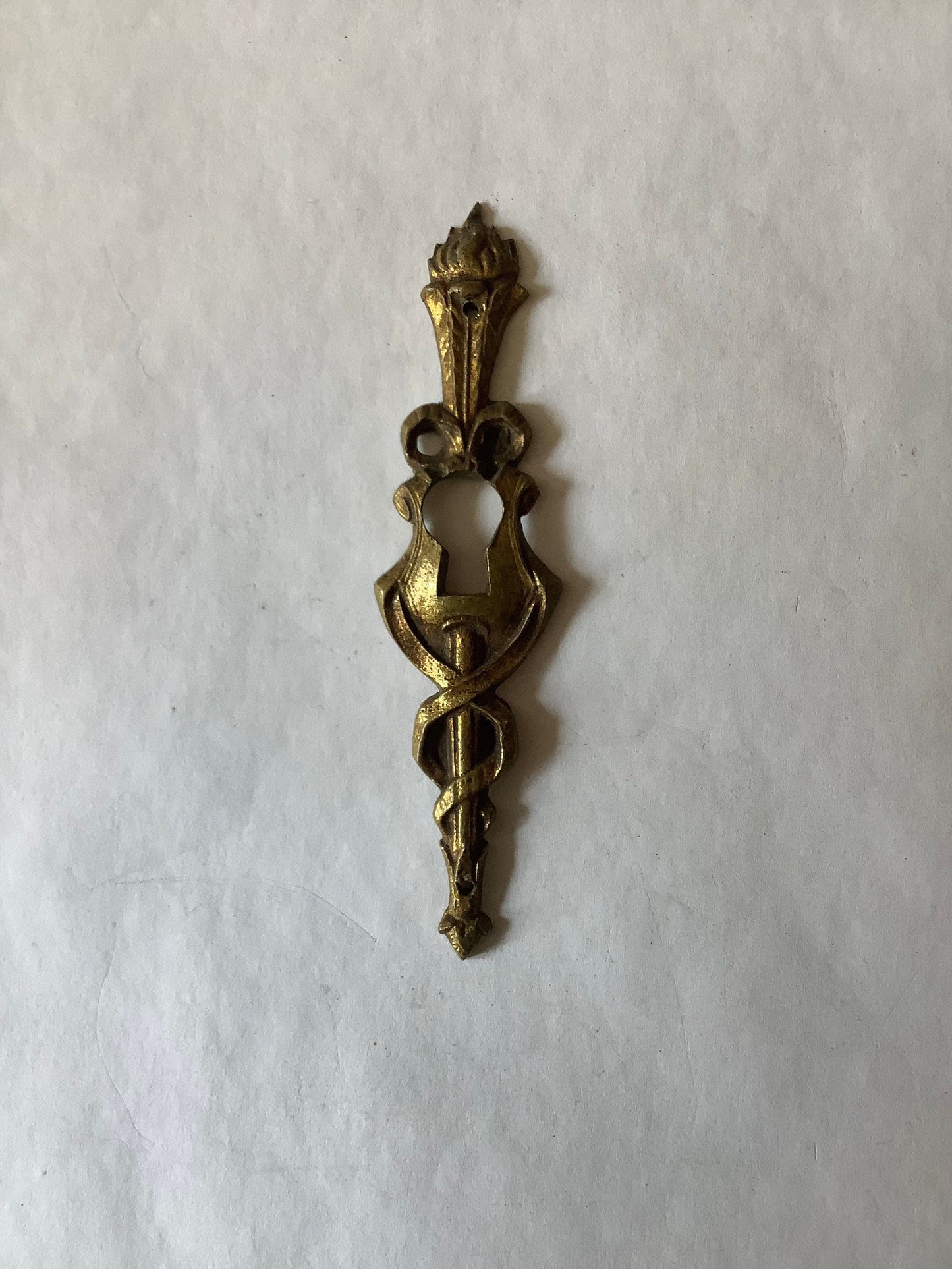 One Antique Brass Ormolu Keyhole Cover Escutcheon made in France in the 1920s elegant torch insignia