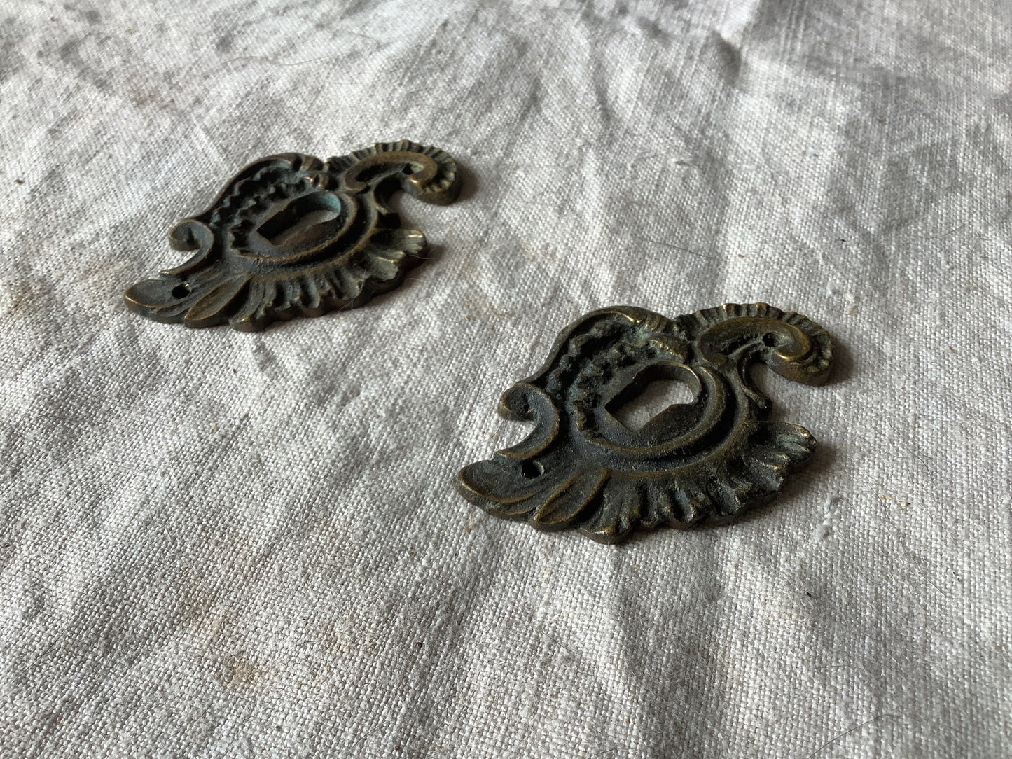 A set of Two matching Antique Brass Keyhole Cover made in France in the 1900s dark with patina