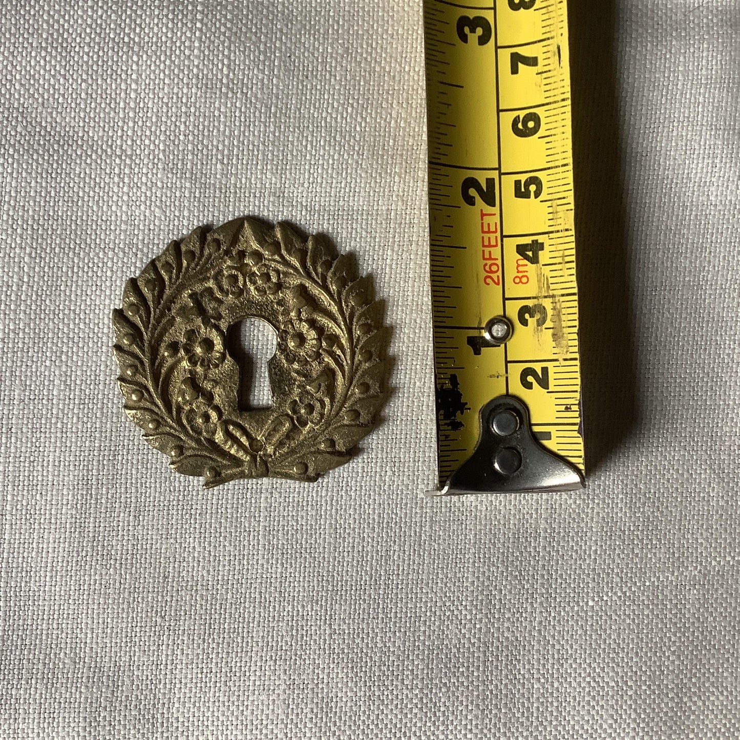 One Antique Brass Ormolu Keyhole Cover Escutcheon made in France in the 1900s elegant flower wreath